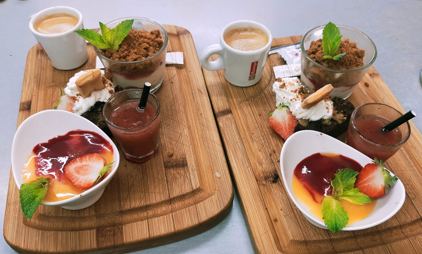 Deux cafés gourmands : expresso, verrine à la crème et spéculoos, dessert aux fruits rouges, sur des planches en bois