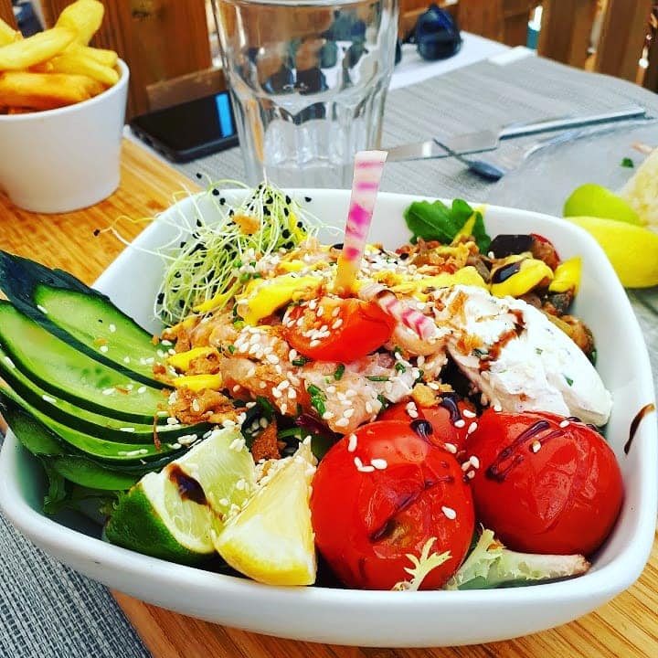 Une salade composée colorée : tomates cerises, concombre, fromage frais, graines de sésame, citron